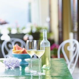calici e bottiglia di vino al sole