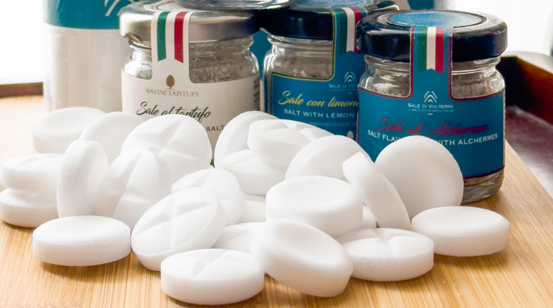 Perle di sale di Volterra e sullo sfondo dei barattolini in vetro di sale aromatizzato