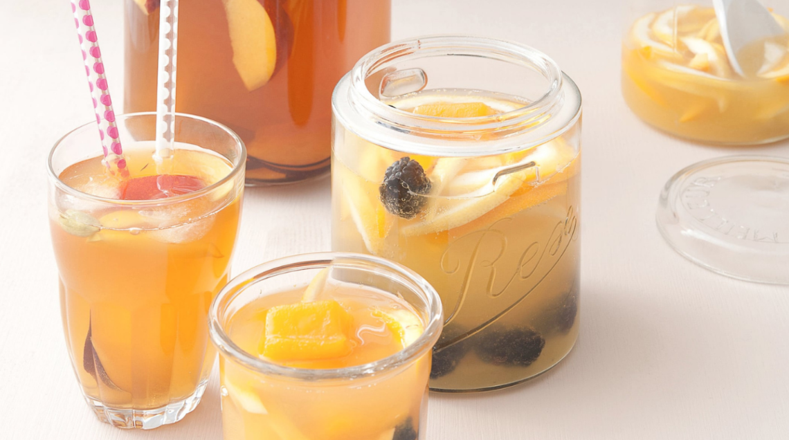 sangria esotica all'interno di bicchieri di vetro. Uno di questi, quello più a sinistra, ha due cannucce