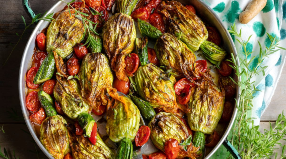 Una teglia ricca di fiori di zucca ripieni al forno
