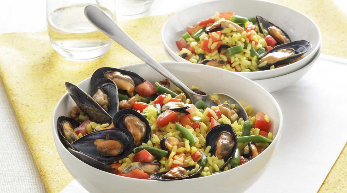 due ciotole bianche contenenti delle insalate di riso ricche di ingredienti come fagiolini, cozze e pomodori