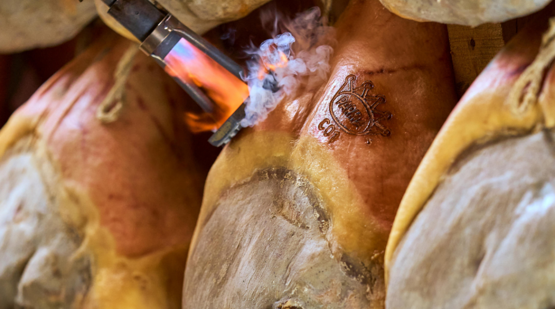 prosciutti di Parma in fase di marchiatura