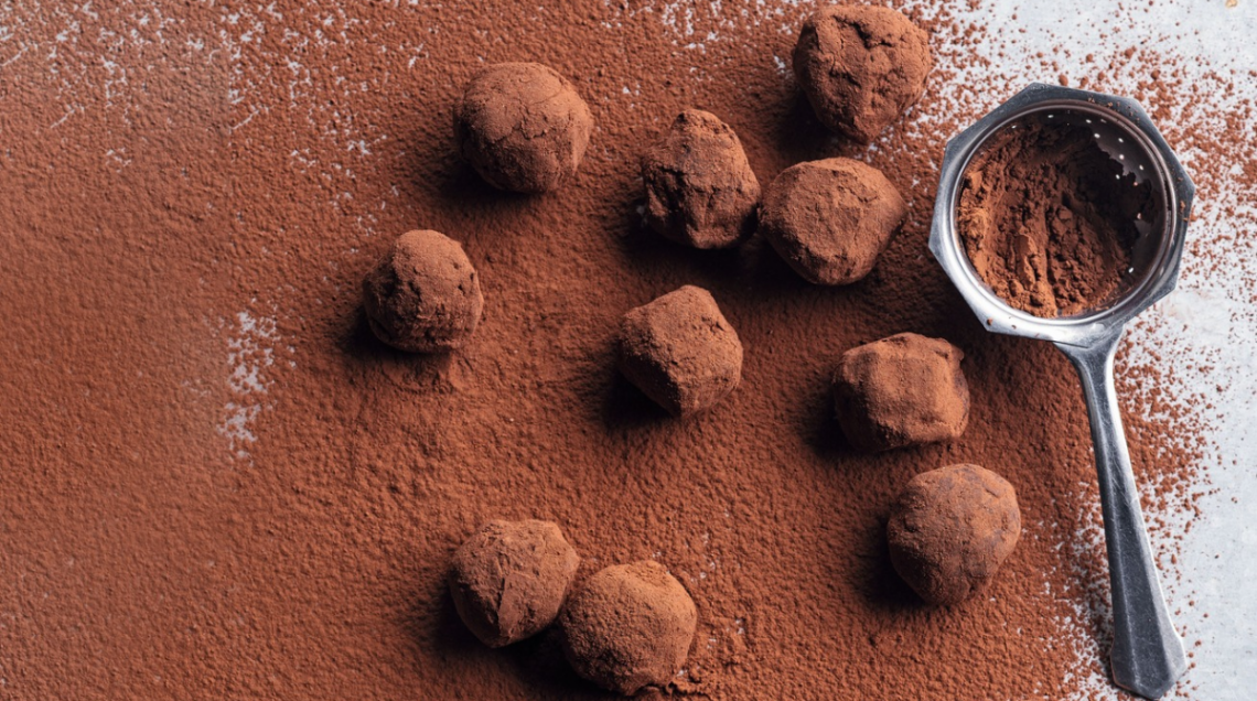 tartufi al cioccolato ricoperti di cacao e un colino