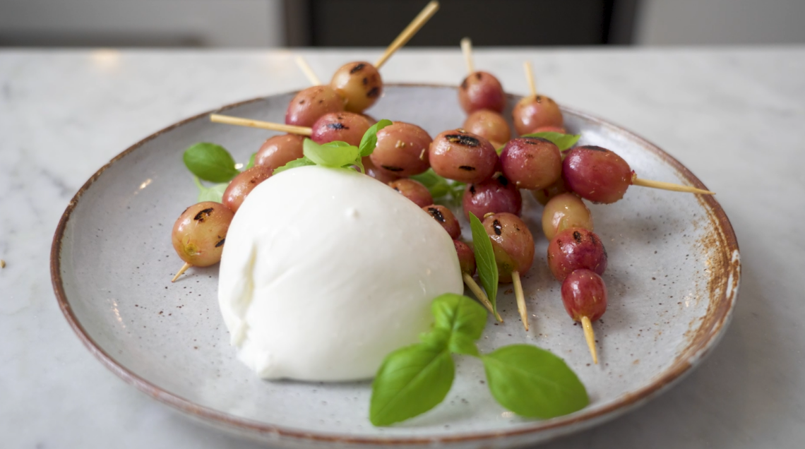 piatto di burrata con spiedini di uva grigliata e basilco