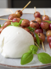 piatto di burrata con spiedini di uva grigliata e basilco
