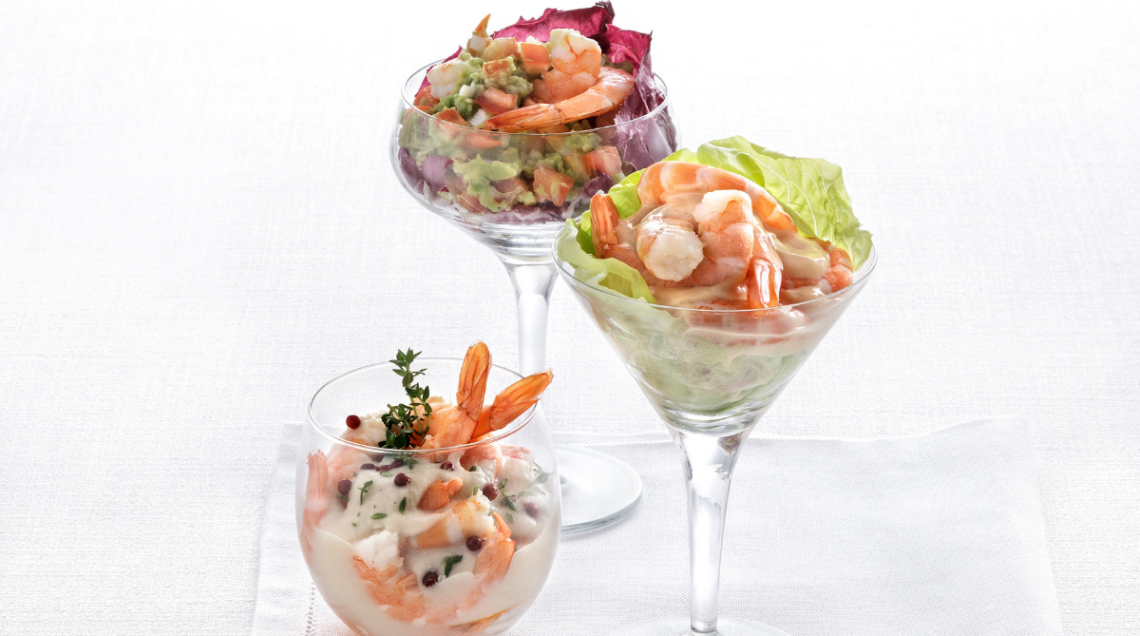 Tre bicchieri da cocktail contenenti gamberi alla salsa rosa
