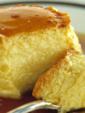 Crème caramel in un piatto con un cucchiaino e un pezzo staccato