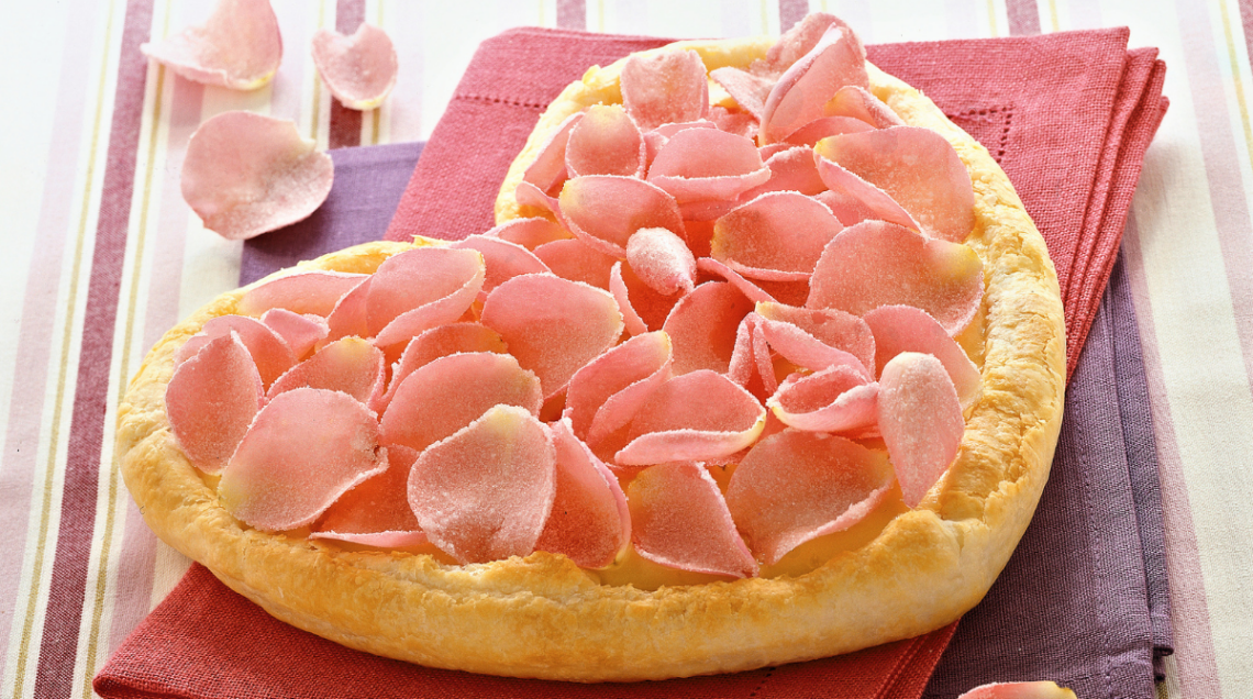torta con crema e petali di rosa a forma di cuore