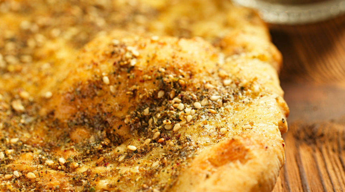 In primo piano, particolare di una pagnotta tipica levantina, condita con olio e miscela di za'atar