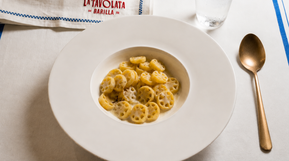 Le famose ruote Barilla cucinate da Massimo bottura servite in un piatto fondo bianco con parmigiano e pepe
