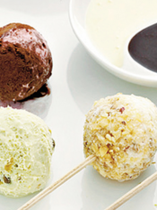 praline di gelato su stecchini ricoperte di salse al cioccolato e granelle assortite