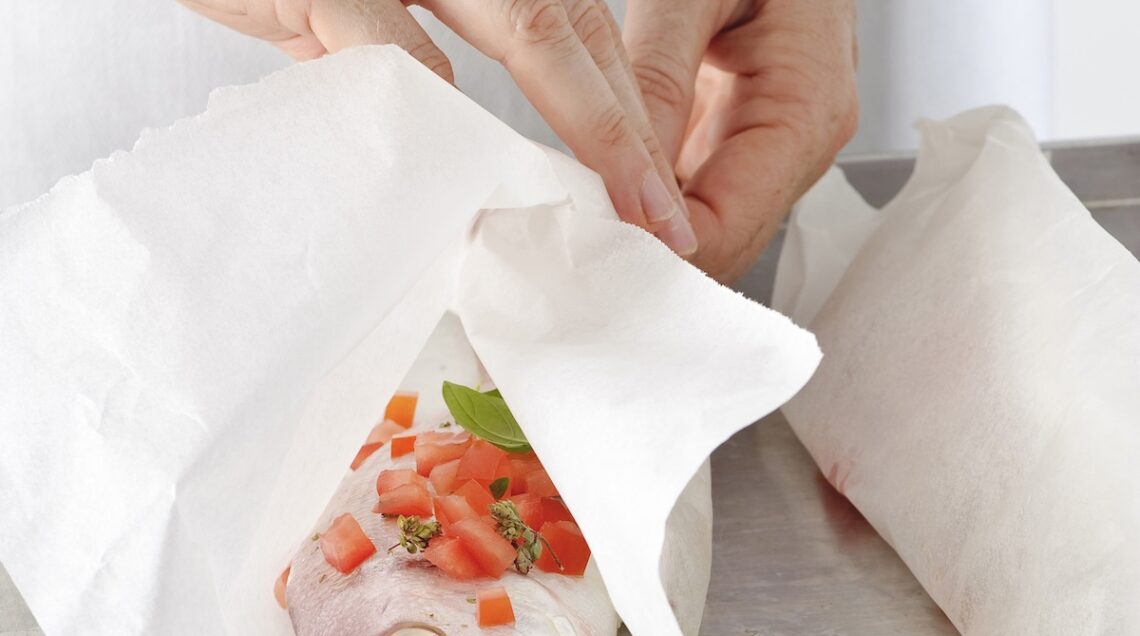 carta da forno avvolta intorno a un pesce per la cottura al cartoccio