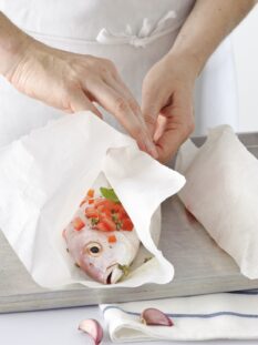 carta da forno avvolta intorno a un pesce per la cottura al cartoccio