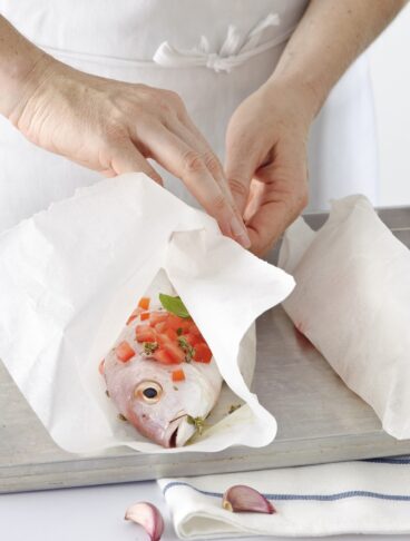 carta da forno avvolta intorno a un pesce per la cottura al cartoccio