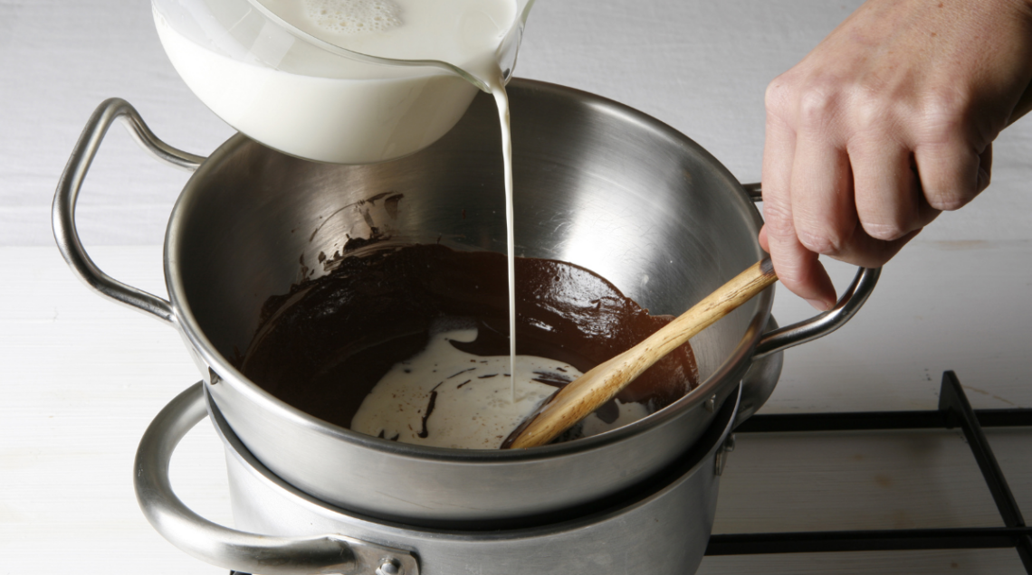 Cottura a bagnomaria di una salsa al cioccolato sul fuoco.