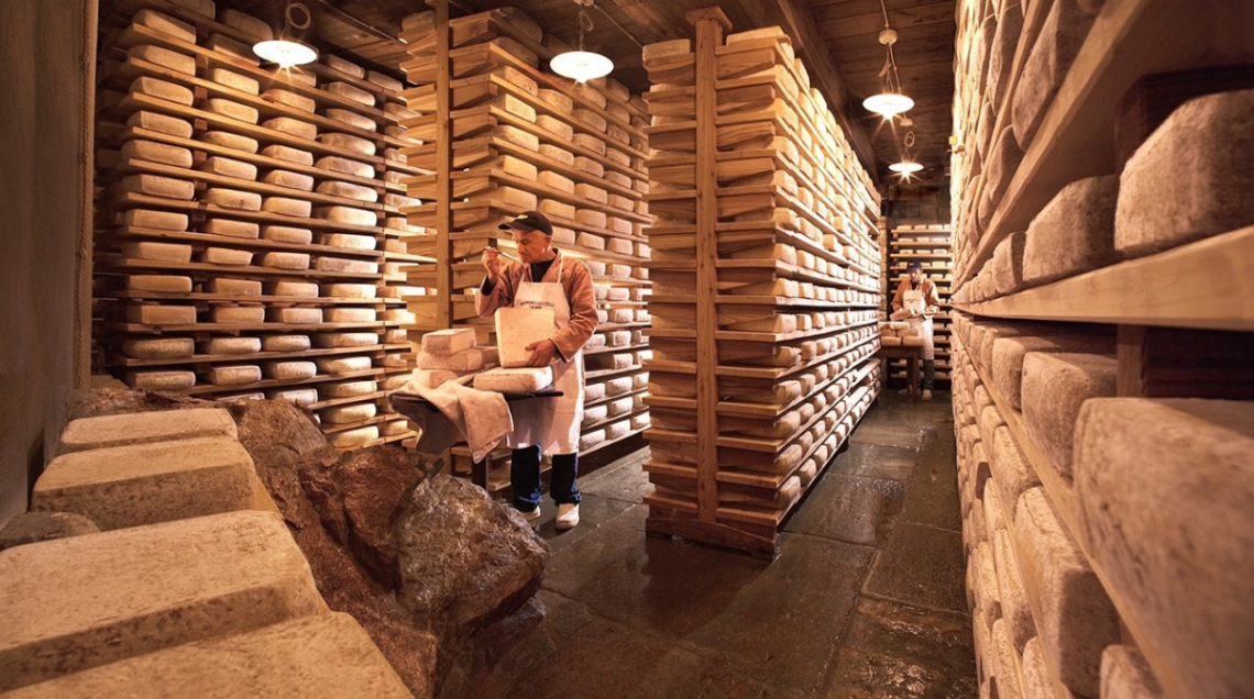 Un operatore all'interno della sala da stagionatura delle forme di formaggio