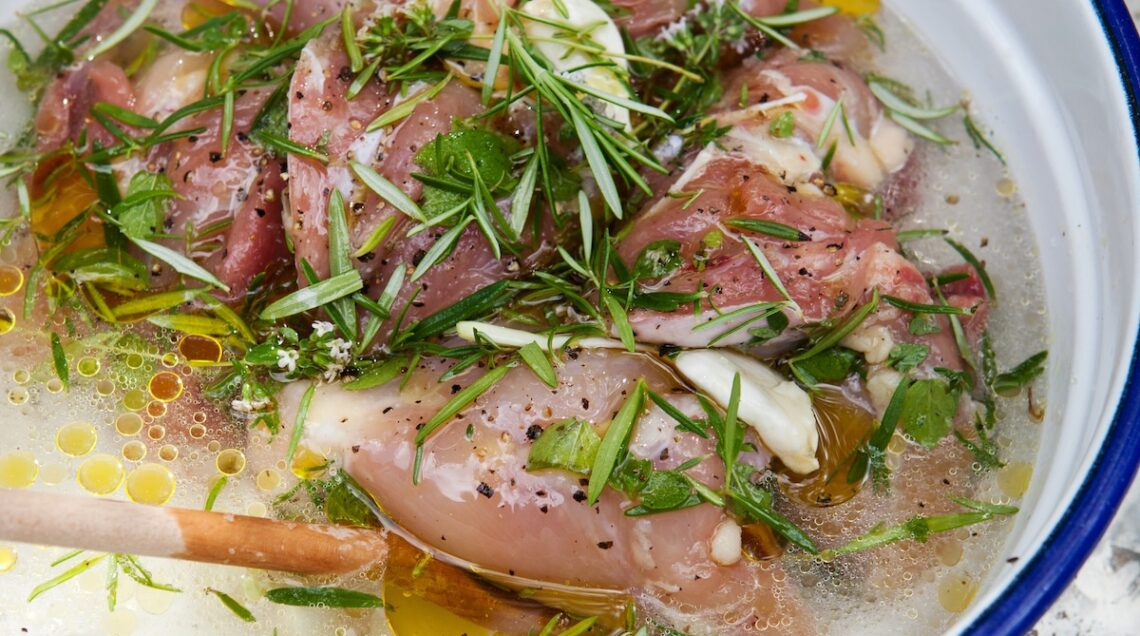 carne immersa in una marinata con erbe aromatiche