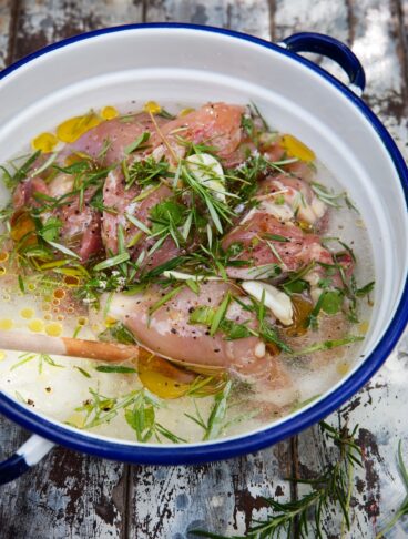 carne immersa in una marinata con erbe aromatiche