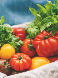 Cassetta di legno con pomodori, carote, basilico e altre verdure