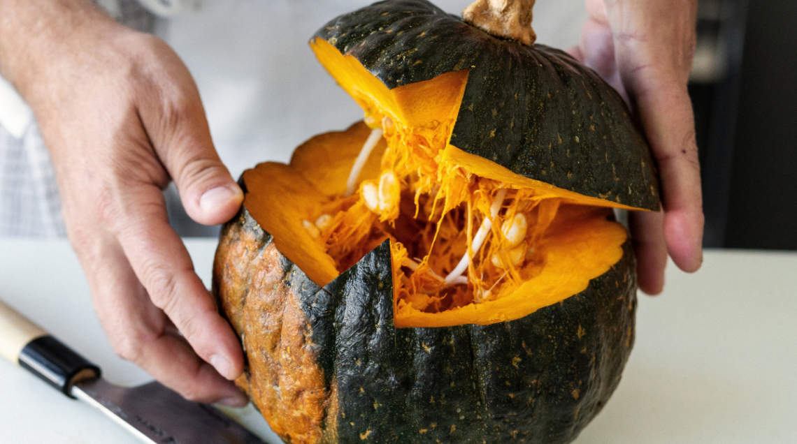 due mani stanno aprendo una zucca