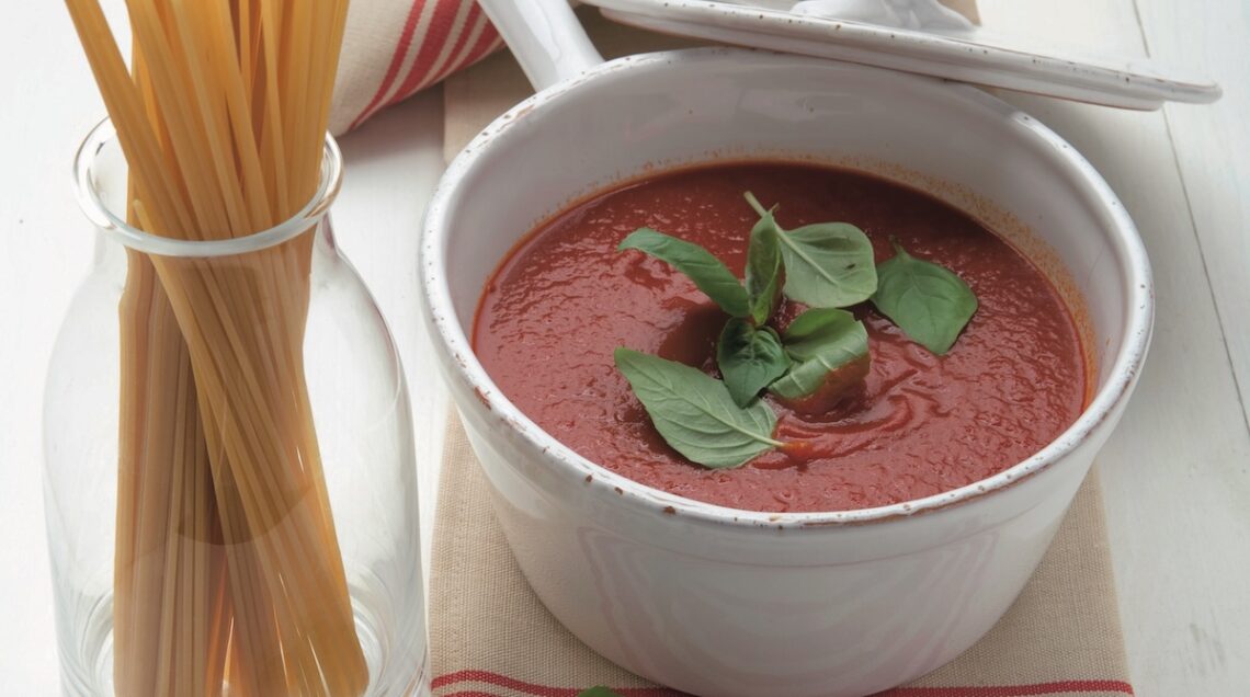 salsa di pomodoro al basilico in pentola con spaghetti crudi