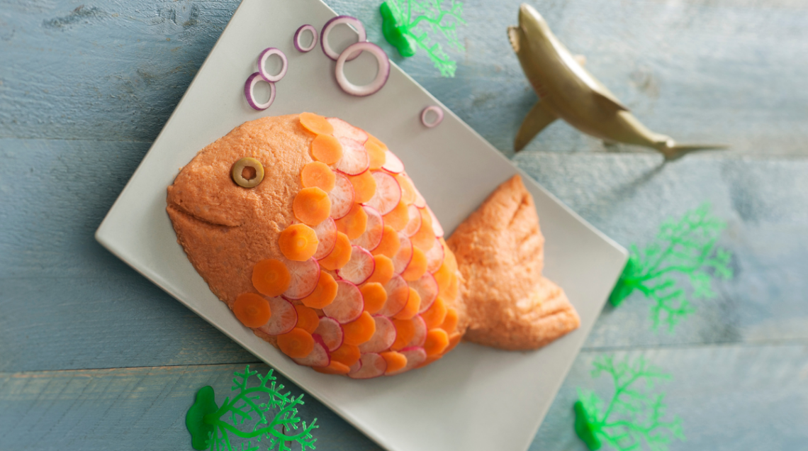 piatto a base di tonno, pietanza a forma di pesce con scaglie e bolle rappresentate da carote e cipolle a rondelle