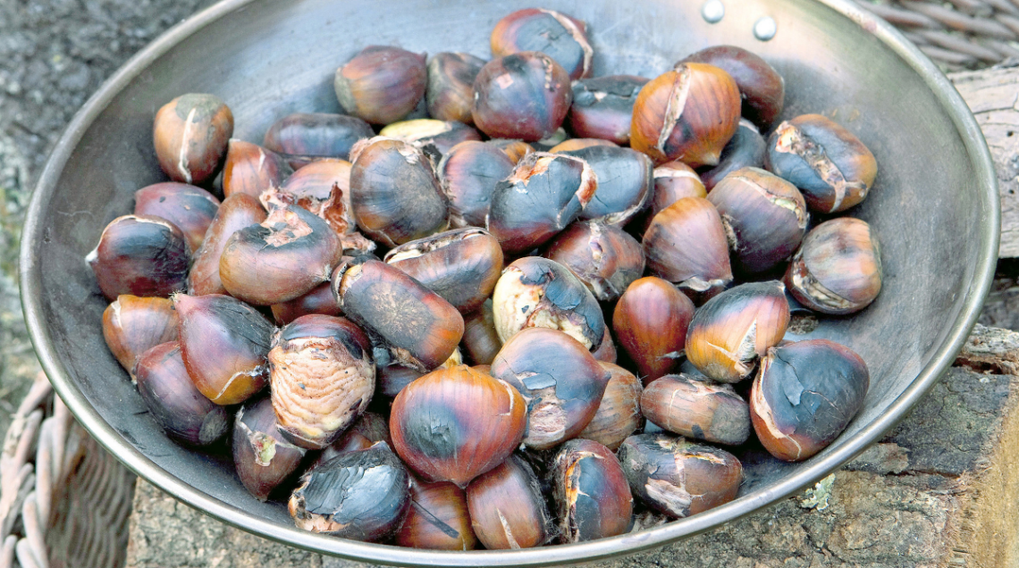 castagne in cottura sull'apposita padella traforata
