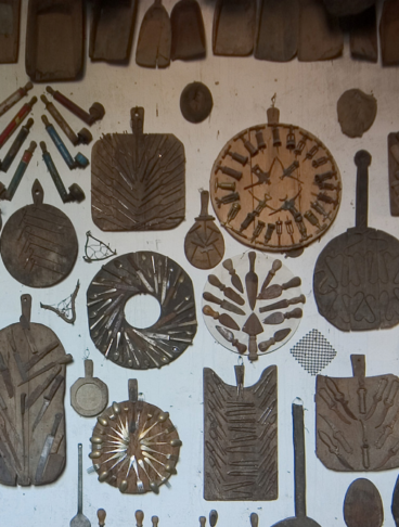 oggetti di vita quotidiana appesi a una parete del museo Guatelli