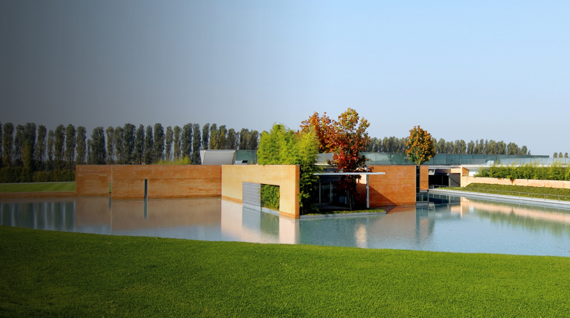 La sede Smeg, un edificio contemporaneo dalle forme geometriche, circondato da un giardino curato e da specchi d'acqua