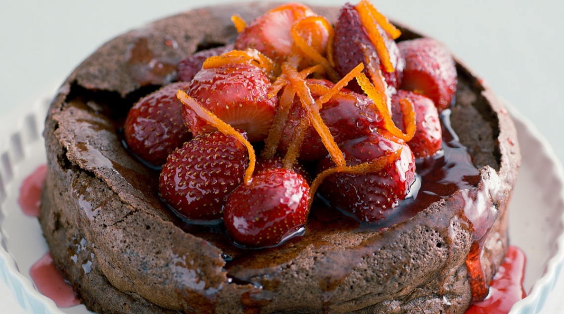 Torta di cioccolato con arance caramellate con scorza d'arancia e fragole