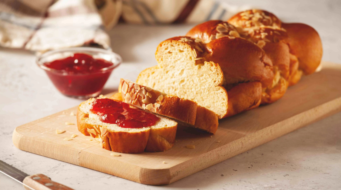 Il pan brioche su un tagliere di legno con marmellata