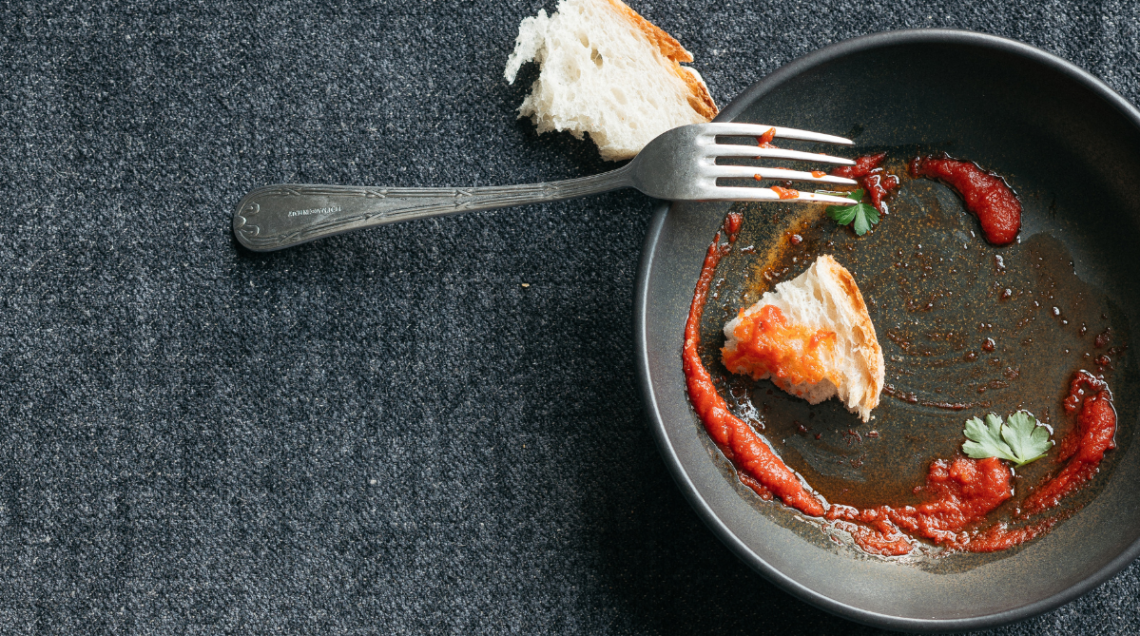 il rito della scarpetta: un piatto nero sporco di sugo, viene ripulito con un pezzo di pane