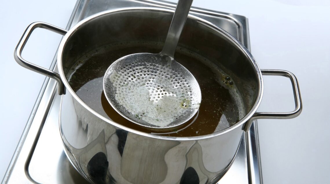 pentola con brodo e schiumarola