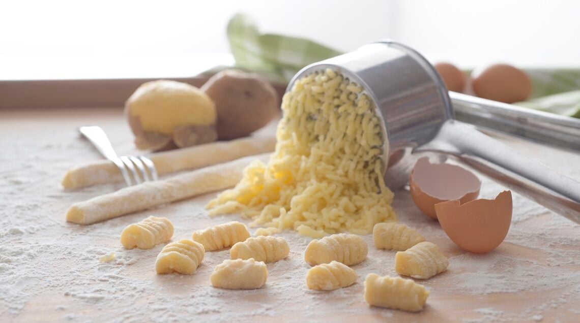 patate passate, gnocchi, uova e farina su un piano di lavoro