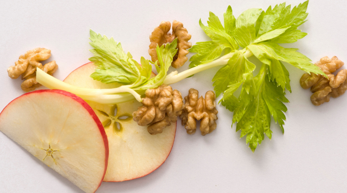 alcuni ingredienti dell'insalata Waldorf: mela, noci e sedano