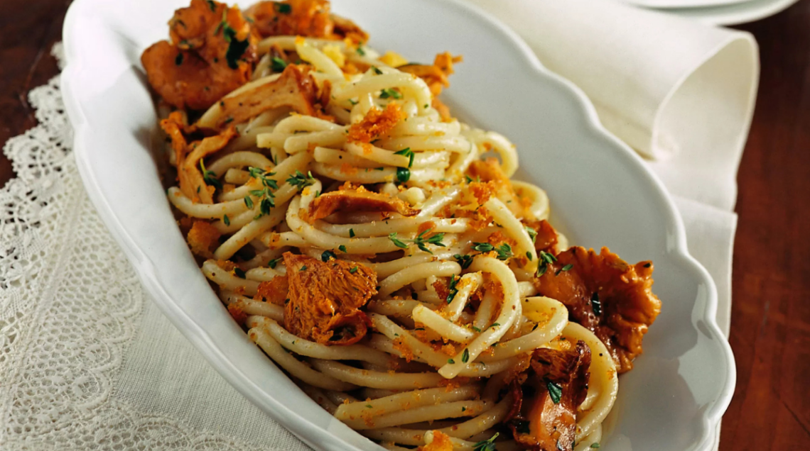 pici ai finferli con briciole fritte in un piatto ovale bianco