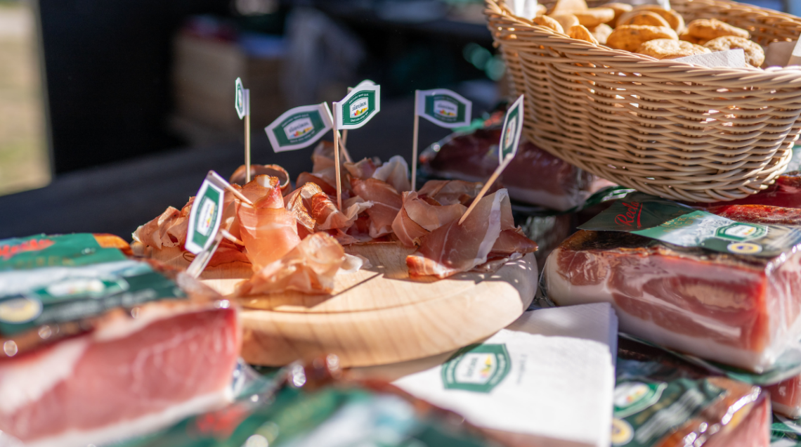 Speck Alto Adige affettato su tagliere di legno