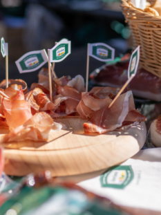 Speck Alto Adige affettato su tagliere di legno
