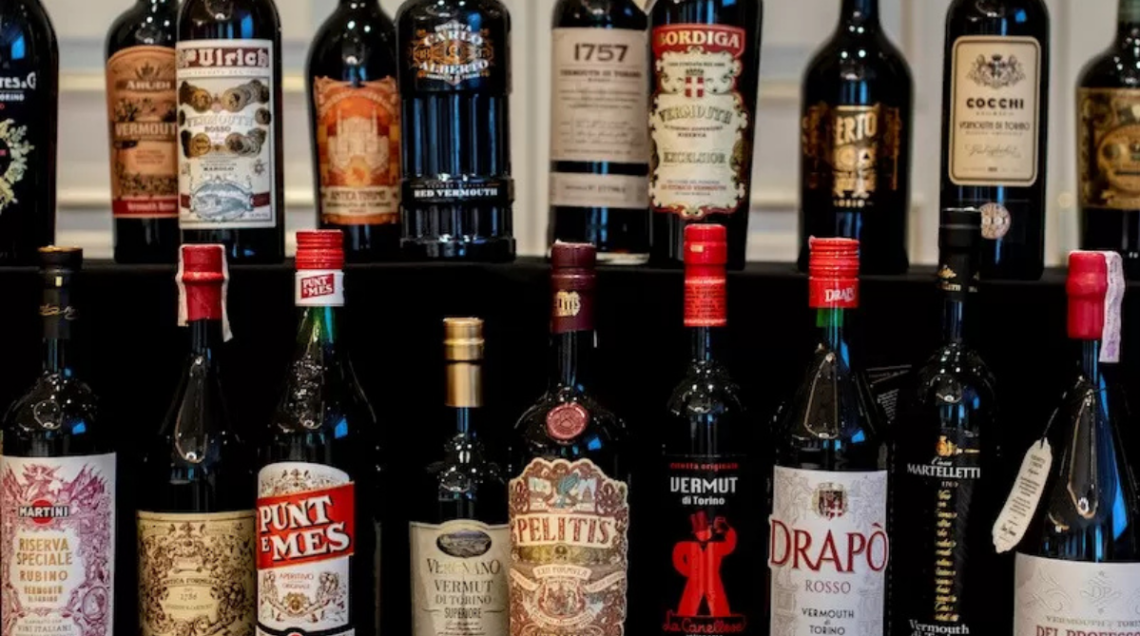 diverse bottiglie di vermouth esposte su uno scaffale
